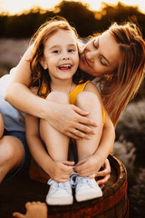 Wall Mural - portrait of a lovely mother and her daughter while girl is looking at camera laughing while mother i