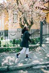 Wall Mural - Portrait of young african woman walking outdoors