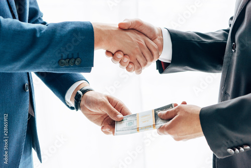 Cuadros en Lienzo cropped view of man giving bribe to business partner and shaking hands in office