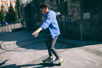 Wall Mural - Hipster male rides on skateboard. boy rides longboard outside