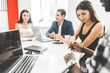 © xartproduction - A team of young office workers, businessmen with laptop working at the table, communicating together in an office. Corporate businessteam and manager in a meeting. coworking.