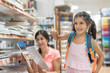 © FotoAndalucia - mother and daughter in store choosing material for back to school