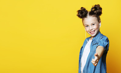 Wall Mural - Portrait of a beautiful and confident girl showing thumbs up isolated one yellow background. Copy space.