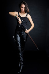 Woman in urban fantasy costumes holding weapons