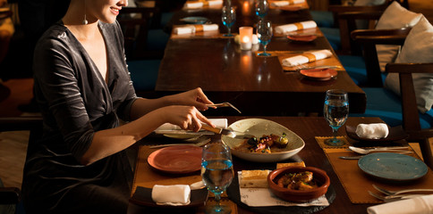 Asian Beautiful Woman have Dinner in luxury roof top restaurant with secret recipe Menu on plate course set of Spanish food Cuisine culinary which a bit hot and unique taste on wooden table.