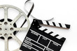 Movie premiere concept with clapperboard, film type on white background top view
