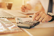 © Rattanasak - Businessman accountant using calculator and laptop for calculating finance on desk office. business financial accounting concept.