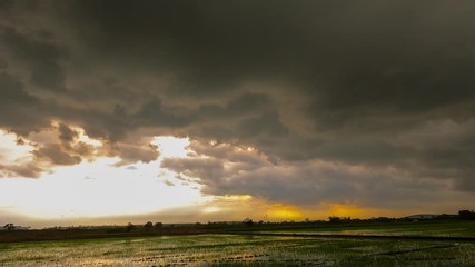 Wall Mural - Time lapse rain clouds and rays light of sunset