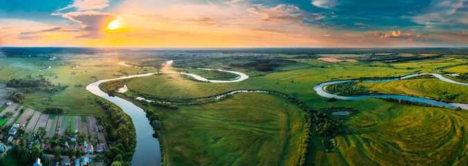 Wall Mural - Aerial View Green Forest Woods Meadow And River Landscape In Sunny Spring Evening. Top View Of Beautiful European Nature From High Attitude In Summer Sunset Sunrise. Panorama, Bird's Eye View. Belarus