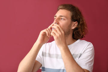 Sticker - Young man with nasal drops on color background