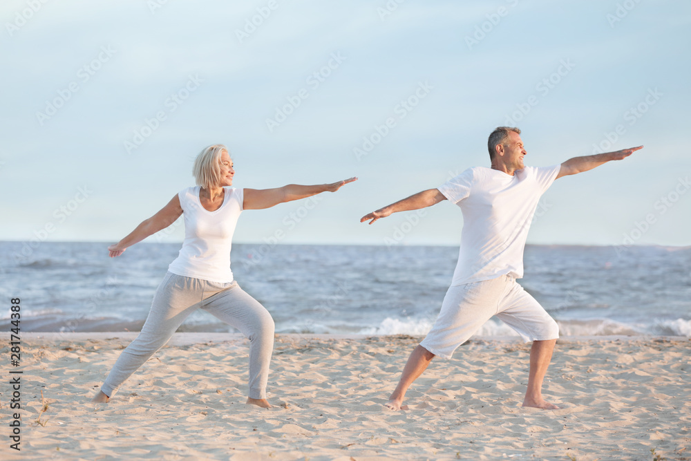 Mature couple training at sea resort