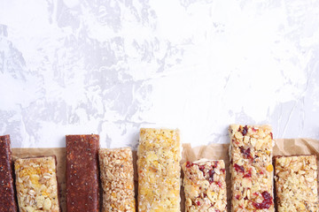 Granola bar on white cement background. Healthy organic sweet dessert snack. Cereal granola bar with nuts and dried fruits.Top view.