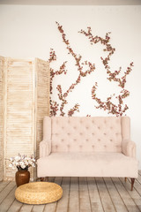 Wall Mural - Pink vintage sofa and screen in rustic style. Interior of a bright Scandinavian living room with flowers on the wall.