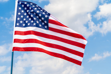 Wall Mural - American flag waving in the wind against blue sky