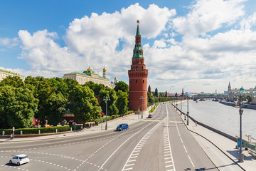 Kremlevskaya embankment of Moskva river in sunny summer morning against blue sky with white clouds