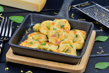 Poster - Italian traditional tortellini pasta in a pan on wooden table