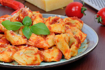 Poster - Italian traditional tortellini pasta in a plate on wooden table