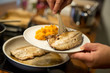 Fischfilet in Butter gebraten auf Teller anrichten, Süsskartoffel Püree, Pfanne und Herd im Hintergrund, Nahaufnahme