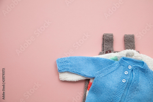 Fotografía Cute knitted baby clothes layout on a pastel pink background