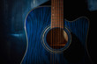 © Andrey Nikitin - Dreadnought acoustic guitar on a blue wooden background in the dark. Copy space