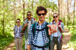 © Syda Productions - travel, tourism, hike and people concept - group of friends with backpacks and man pointing finger to you in forest