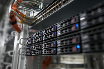 Computer Server mount on rack in data center room with red lighting alarm.