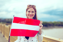 Young Redhead Woman Holding Austrian Flag On Bridge