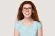 Headshot portrait funny woman in glasses laughing on grey background