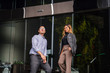 © Danon - A tall, confident and clean-cut Asian man in shirt and pants smiles as he gives a tour or directions to the city to a young and beautiful Malay Asian woman in a suit during the day.