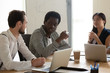 Focused multiracial business team talking brainstorming sit at boardroom table