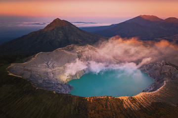 Aerial view of Kawah Ijen volcano with turquoise sulfur water lake at sunrise. Panoramic view at East Java, Indonesia. Natural landscape background.