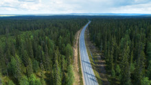 Aerial View From Above Of Country Road Through The Green Summer Forest In Lapland. Beautiful Fir Trees. Drone Photography.