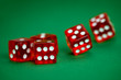 five rolling red dices on green background
