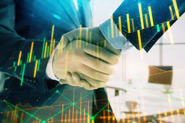 Multi exposure of financial graph on office background with two businessmen handshake. Concept of success in business