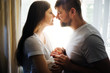 © Svetlana - Father and mother with a newborn son against the background of the window in the backlight. New young multi-generation family. Breast-feeding