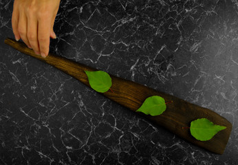 THREE GREEN LEAF ON THE BOARD ON A DARK BACKGROUND