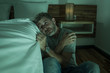 © TheVisualsYouNeed - dramatic home portrait of young desperate and depressed lonely man sitting on bedroom floor crying sick suffering anxiety crisis and depression problem feeling helpless