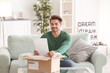 © Africa Studio - Young man unpacking parcel at home