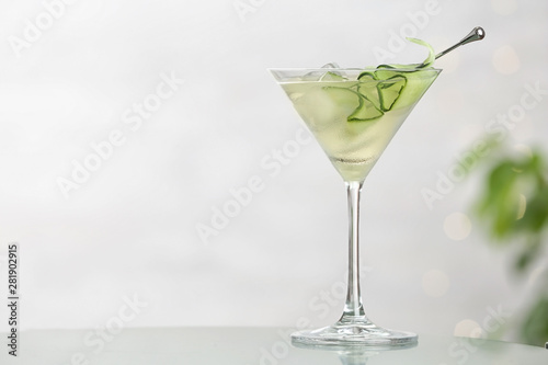 Fotografía Glass of tasty cucumber martini on table against light background, space for tex