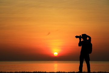 Sticker - Silhouette of photographer with his camera on sunrise