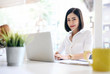 © NAMPIX - Portrait of beautiful businesswoman working with laptop while sitting at office desk.