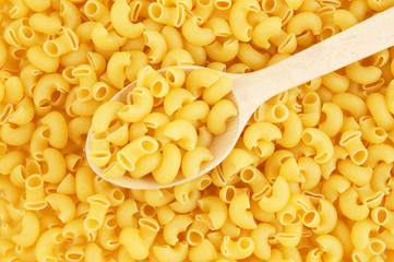 Macaroni background with wooden spoon