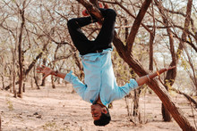 Indian Model Hanging Upside Down From The Tree