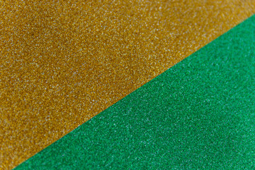 Wall Mural - Golden and green sparkling background from small sequins, closeup. Brilliant shiny backdrop from textile. Shimmer paper