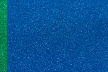 Wall Mural - Green and blue sparkling background from small sequins, closeup. Brilliant shiny backdrop from textile.