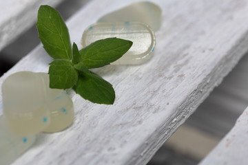 Peppermint candies for breath freshening. With refreshing microgranules. Cooling menthol for sore throat. On white painted wooden boards.