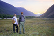 © Sergey - Hikers with backpacks relaxing. Happy couple feel freedom and enjoy the beautiful autumn forest in the mountains and looking together on sunset.