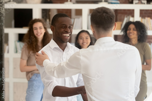 Cuadros en Lienzo Diverse company head shake hands african employee during reward