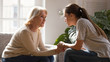 © fizkes - Different generations women talking holding hands giving psychological support