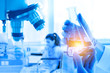© KINGKAN - Double Exposure, hand holding flask, microscope, in medical research at laboratory, patient with health problems. Healthcare, pharmaceutical and medical concept.